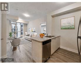 A kitchen with a dining table and chairs in a staged apartment.