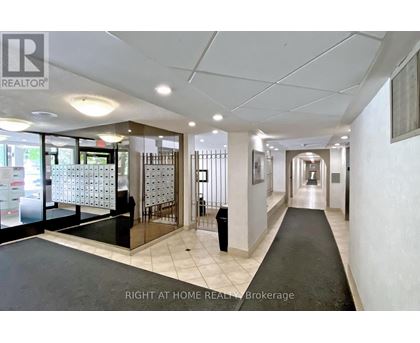 A hallway with a black carpet and white walls.