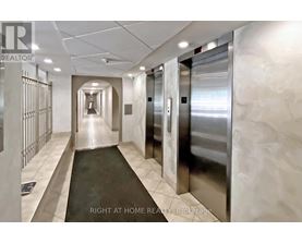 A hallway with a metal elevator and a sign that says "Right at Home REALTY Brokerage".