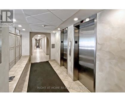 A hallway with a metal elevator and a sign that says "Right at Home REALTY Brokerage".