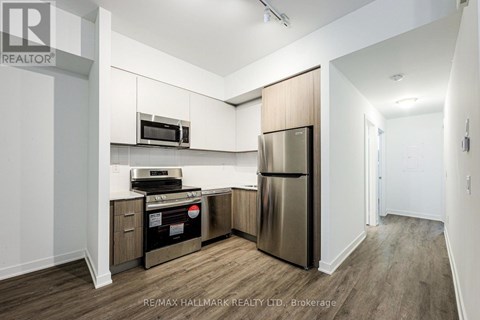 A kitchen with a stainless steel refrigerator and microwave.
