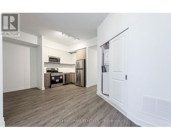 A kitchen area with a refrigerator, microwave, and oven.
