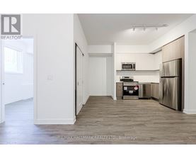 A kitchen area with a refrigerator, microwave, and oven.