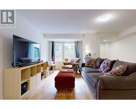 A living room with a flat screen TV on a wooden stand.