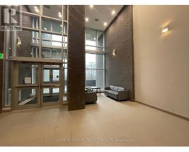 A hallway with a glass door and a brick pillar.