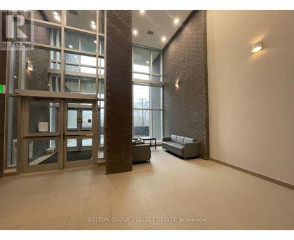 A hallway with a glass door and a brick pillar.
