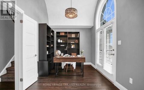 A dining room with a table set for two and a chandelier hanging from the ceiling.