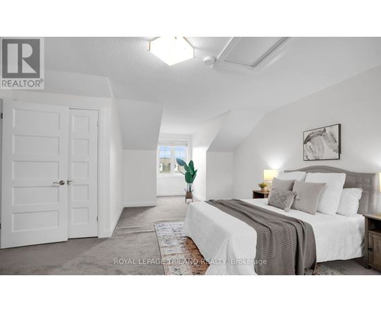 A bedroom with a large bed and a white door.