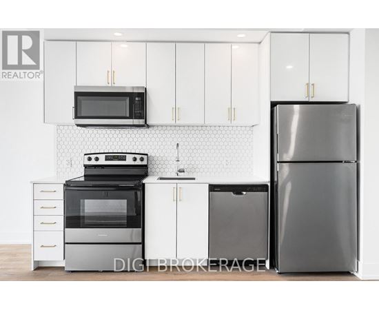 A modern kitchen with a black refrigerator, white cabinets, and a black stove top oven.