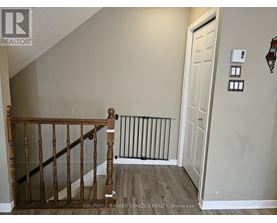 A hallway with a white door and a wooden staircase.