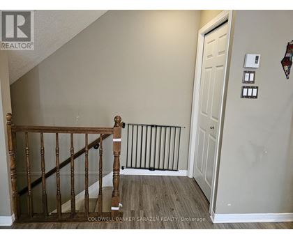 A hallway with a white door and a wooden staircase.