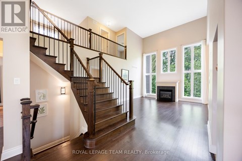 A spacious living room with a fireplace and a staircase.