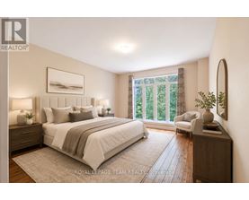 A well-lit bedroom with a large bed and a view of greenery outside the window.