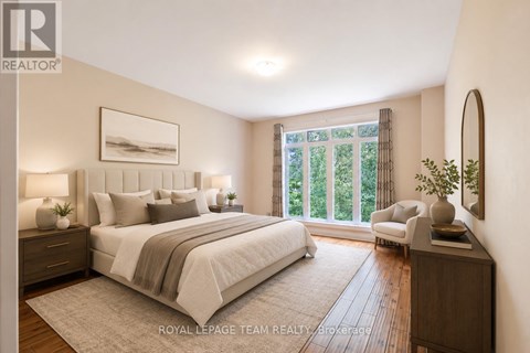 A well-lit bedroom with a large bed and a view of greenery outside the window.