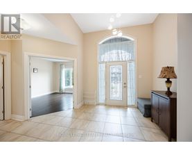 A spacious room with a large window and a lamp on a side table.