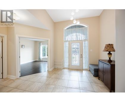 A spacious room with a large window and a lamp on a side table.