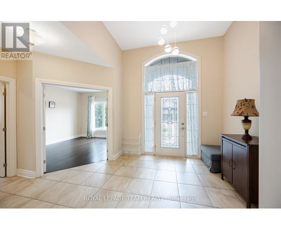 A spacious room with a large window and a lamp on a side table.
