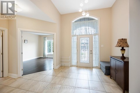 A spacious room with a large window and a lamp on a side table.