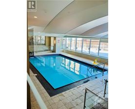 A large indoor swimming pool with a glass barrier.