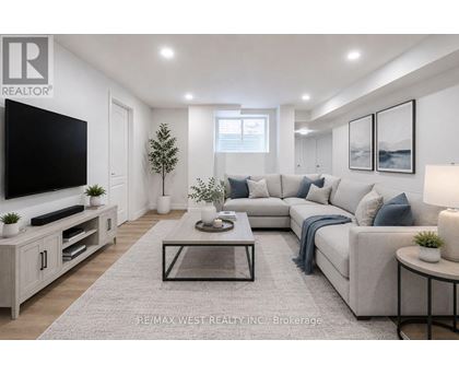 A modern living room with a grey sofa, a glass coffee table, and a television on a cabinet.