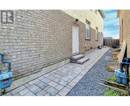 A brick building with a white door and a small patio area.