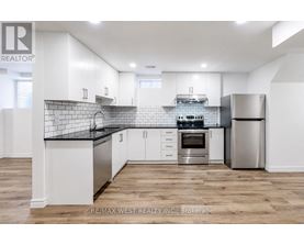 A modern kitchen with white cabinets and stainless steel appliances.