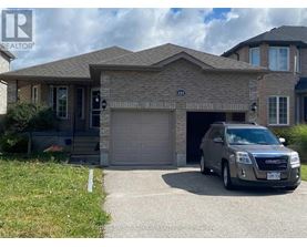 A grey SUV is parked in front of a house with a garage.