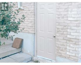 A white door is on the right side of a white brick wall.