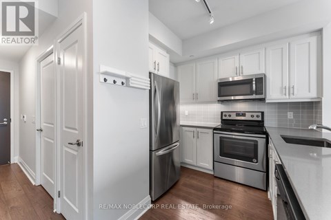 A kitchen with white cabinets and stainless steel appliances.