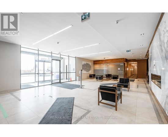 A spacious lobby with a reception desk and chairs.