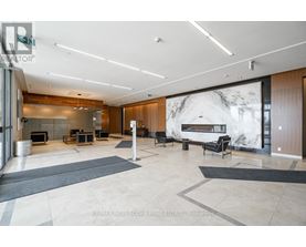 A spacious living room with a fireplace and a large marble wall.