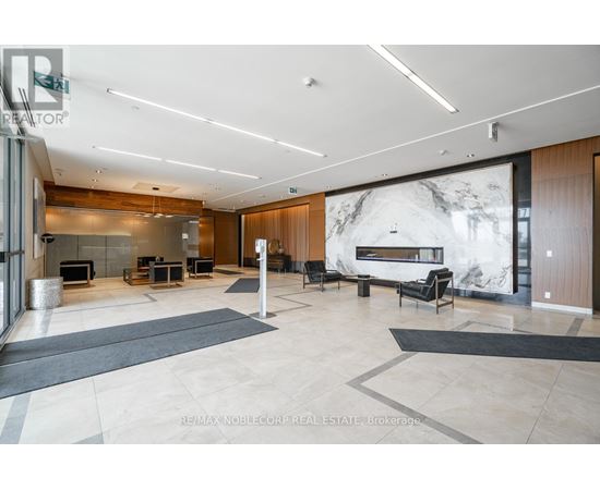 A spacious living room with a fireplace and a large marble wall.