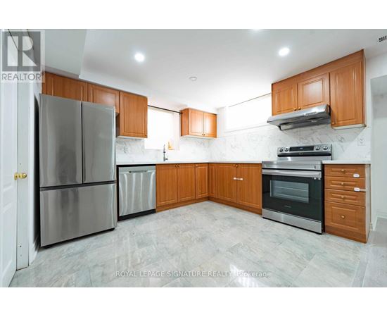A kitchen with a refrigerator, oven, and cabinets.