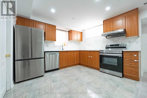 A kitchen with a refrigerator, oven, and cabinets.