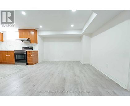 A spacious kitchen with wooden cabinets and a black oven.