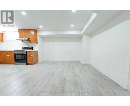 A spacious kitchen with wooden cabinets and a black oven.