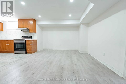 A spacious kitchen with wooden cabinets and a black oven.