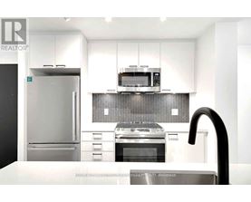 A modern kitchen with a stainless steel refrigerator, oven, and microwave.