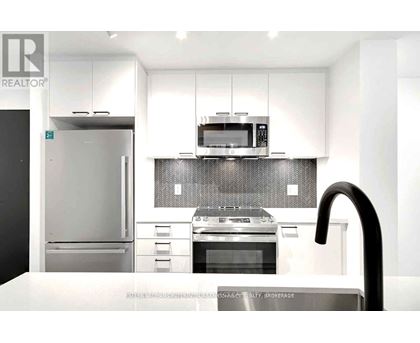 A modern kitchen with a stainless steel refrigerator, oven, and microwave.