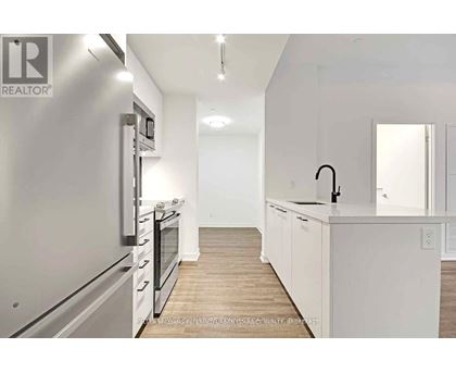 A modern kitchen with white cabinets and stainless steel appliances.