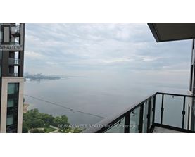 A balcony overlooks a body of water with a cityscape in the distance.
