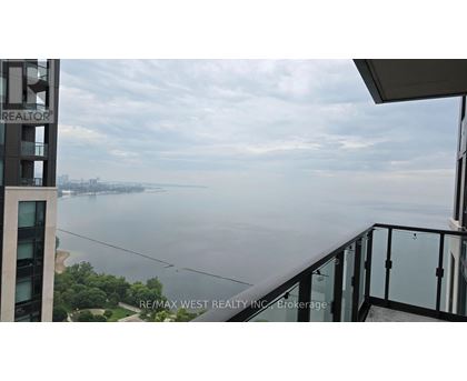 A balcony overlooks a body of water with a cityscape in the distance.