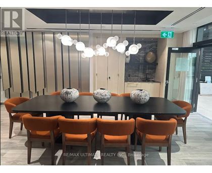 A dining room with a black table and orange chairs.