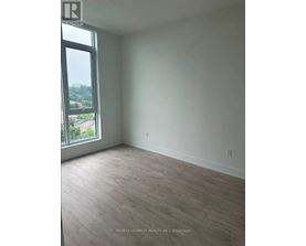 A room with a large window and wooden flooring.