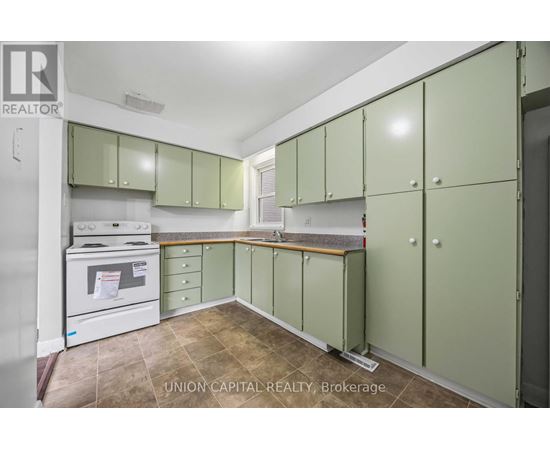 A kitchen with green cabinets and a white oven.