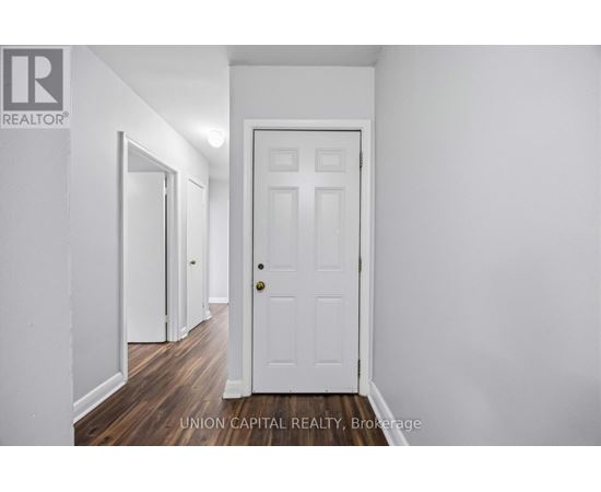 A white door is in the middle of a hallway.