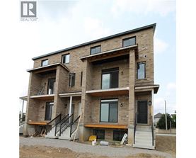 A large, multi-story residential building under construction with visible wooden beams and brickwork.
