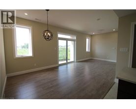 A large empty room with wooden floors and a chandelier.