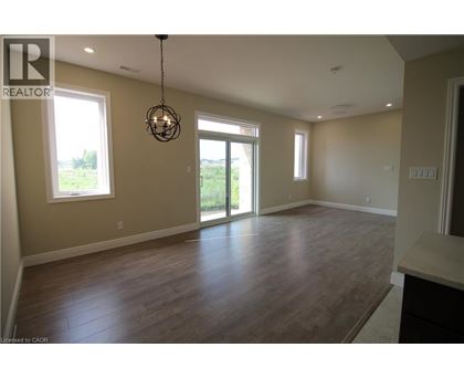 A large empty room with wooden floors and a chandelier.