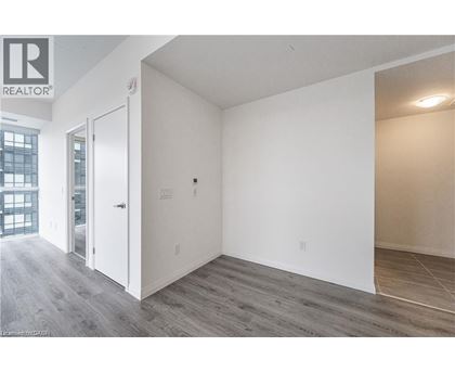 A room with a white door and a window with a view of a building outside.